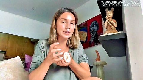 Blonde woman holding vagina sex toy in licking and fingering tutorial