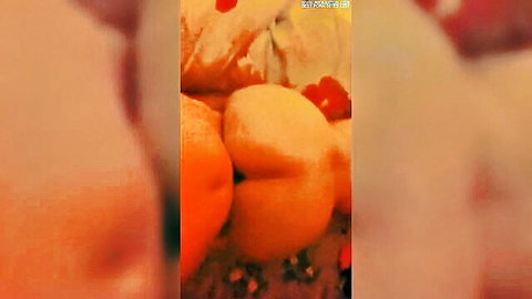 Blurry close-up of juicy oranges and split peach in sensual fruit display