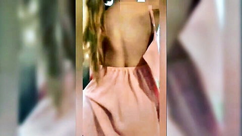 Blonde woman in sexy pink backless dress, teasing back view