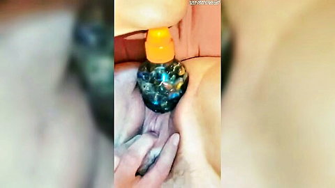 Close-up of mature woman's swollen gaping pussy pumped with orange suction toy exposing pink insides