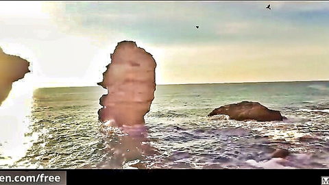 Dramatic sunset over ocean waves and towering rock stack with birds flying