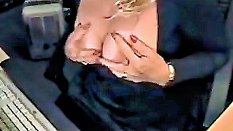 Busty blonde squeezes her huge bare tits together at office desk webcam