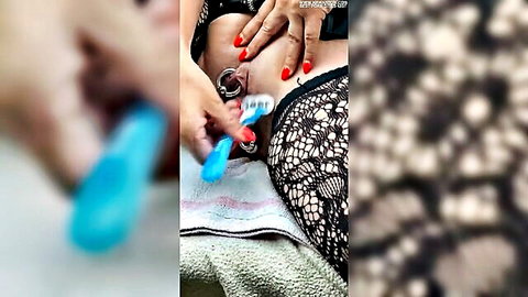 Close-up of woman shaving her pussy with blue trimmer, lace panties aside