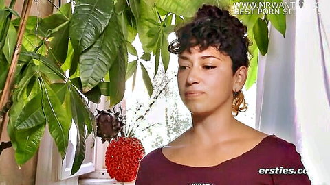 Curly-haired woman in maroon top, exploring body for orgasms - Ersties solo tease