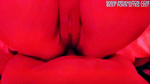 Close-up of woman's red-tinted big ass and exposed pussy from behind