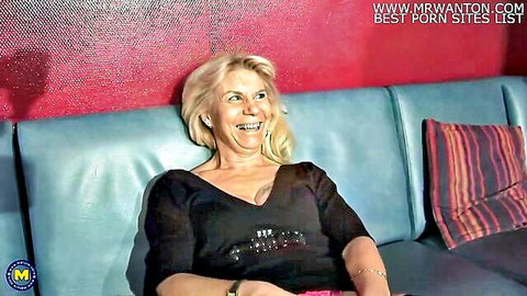 Mature blonde mom in low-cut top smiling seductively