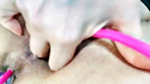 Gloved hand inserting pink dildo into shaved wet pussy in BongaCams MILF video