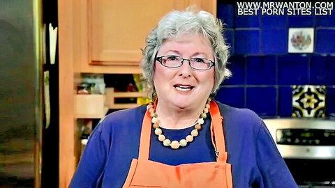Smiling mature granny with gray hair and glasses in apron, kitchen tease