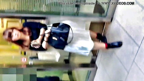 Sexy Asian babe in short white skirt upskirt tease showing thighs and ass in public