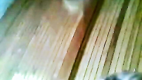 Blurry closeup of green-tinted wooden slats and floor planks in amateur video.