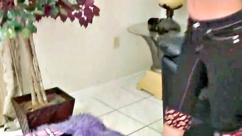 Bent over woman exposes shaved pussy and ass in black latex harness on casting couch