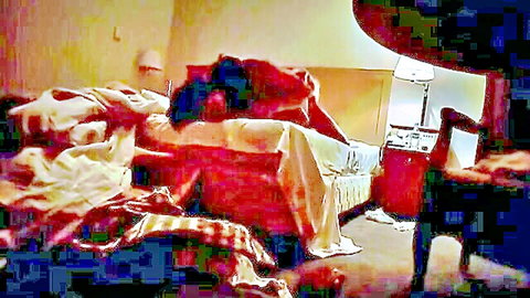 Entangled couple under rumpled sheets in intimate bedroom scene