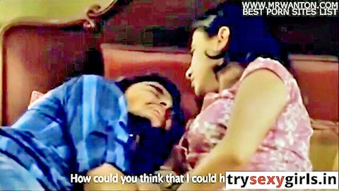 Indian wife leaning over husband in bed, teasing threesome scene