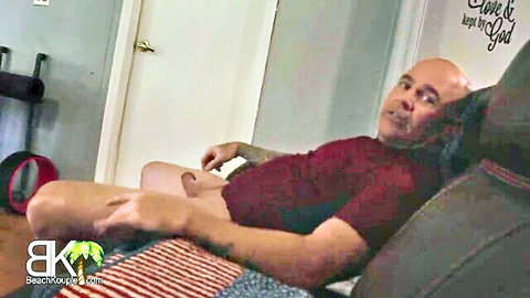 Bald tattooed stepdad exposes erect cock on couch in freeuse family scene