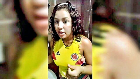 Curvy Latina in cropped Colombia soccer jersey teases cleavage in bathroom