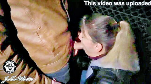 Blonde ponytail woman kneels sucking man's cock while he grips her head in leather jackets