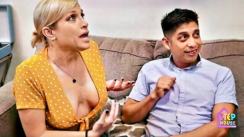 Blonde MILF with big tits in low-cut yellow polka-dot dress talks surprised to stepson on couch