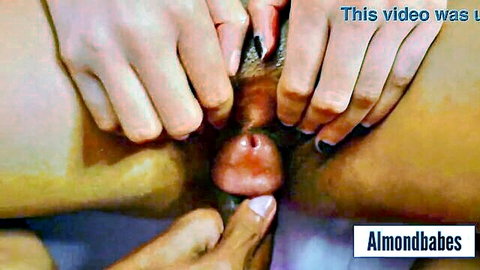 Fingers spreading open shaved Asian pussy exposing wet pink vulva closeup