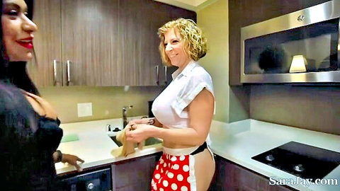 Curvy blonde MILF with huge tits and exposed ass in polka-dot apron teases busty Latina brunette in kitchen