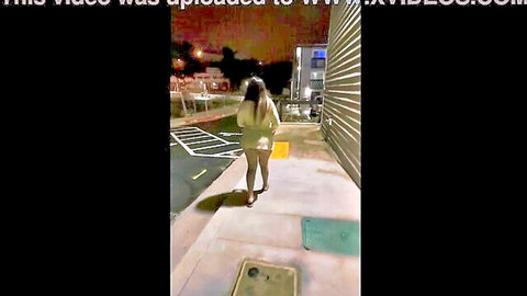 Brunette walking in short yellow dress from behind at night, teasing legs and ass
