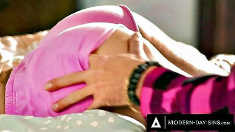 Hand spreading pink panties aside exposing woman's bare ass cheeks on bed