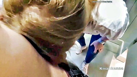 Blonde nurse in white uniform cap stands over POV in tiled locker room