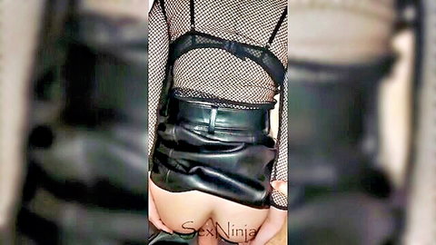 Sexy woman in black leather skirt and fishnet top exposing round ass for anal play