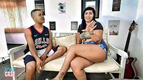 Curvy brunette Latina woman teasing with ebony man in tank top and shorts