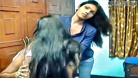 Two sensual Indian women embracing from behind in a bedroom, long hair and tight clothes teasing curves