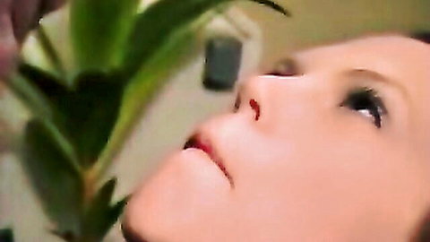 Seductive woman with parted lips looking up amid flowers, teasing swallow vibe