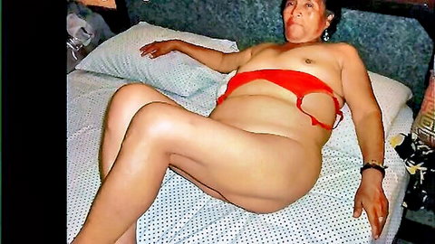 Mature Latina Tina nude in red cutout lingerie, exposing tits and pussy on bed