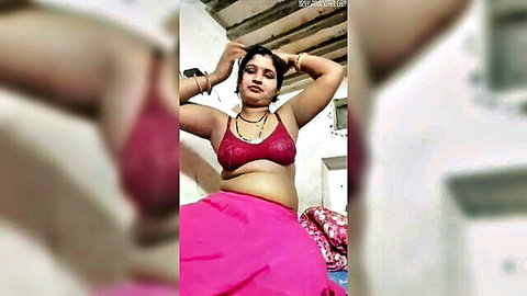 Sexy Desi woman in red bra and pink skirt posing with arms raised