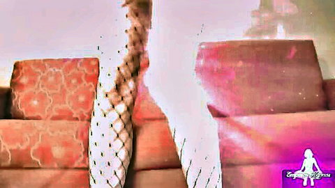 Sissy in white fishnet stockings, legs spread on couch