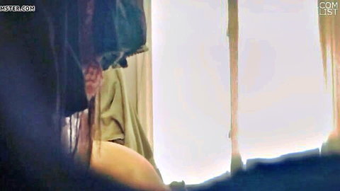Asian woman in green dress exposing curves by window in Third Day of Christmas scene