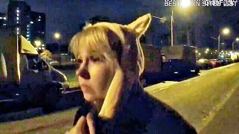 Blonde mature woman in cat ears, surprised outdoor night expression