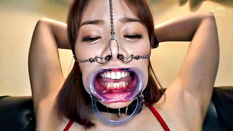 Asian JAV beauty in BDSM gag and collar, wide open mouth masochist pose