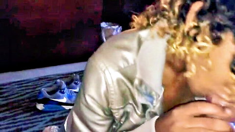 Curly blonde woman giving blowjob in shiny jacket