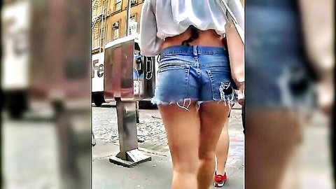 Upskirt tease of slim white woman in tiny frayed denim shorts walking street