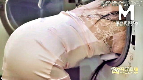 Asian woman in pink lace lingerie bent over, stuck in washing machine