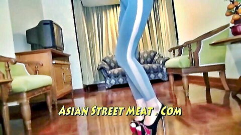 Enchanting Asian woman in tight blue pants and red high heels