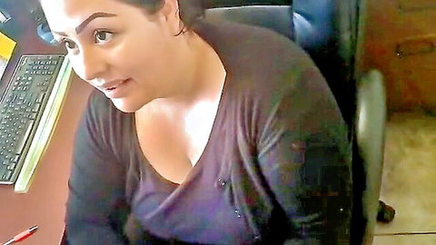 Curvy brunette mature woman teasing huge tits cleavage in office chair