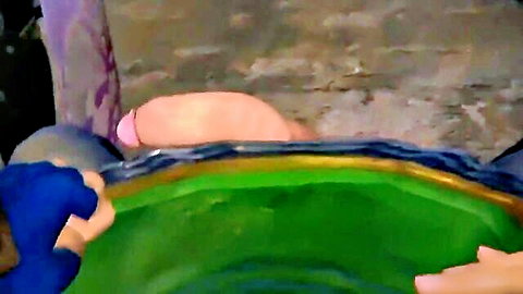 Man holds erect cock over green bowl held by blue-gloved hand for cumshot