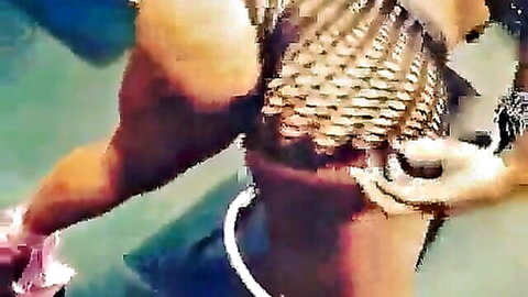Ebony woman with muscular build in fishnet top, ass grabbed in water scene