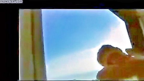 Blonde woman in white dress by sunny window, vacation 2012 amateur scene
