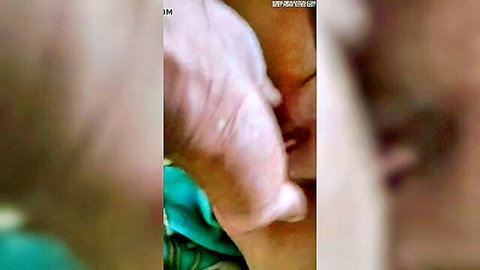 Blurry close-up of light-skinned woman in green dress kissed passionately