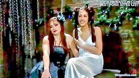 Two busty women in festive dresses enjoy lesbian holiday intimacy
