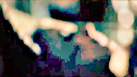 Blurry close-up of pale hands reaching in dim shadows, erotic mystery tease
