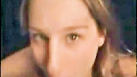 Seductive close-up of fair-skinned brunette MILF with green eyes and long hair staring intensely