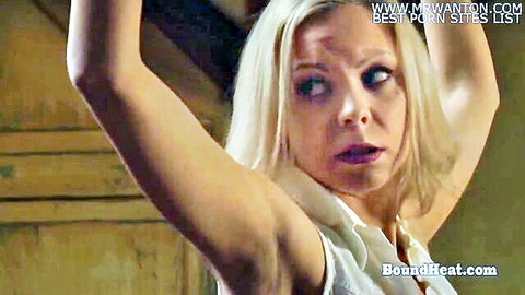 Blonde woman raises arms in bondage surprise wearing white top