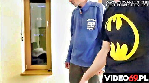Two guys in Batman shirt and blue hoodie stand by mirrored Samsung wardrobe